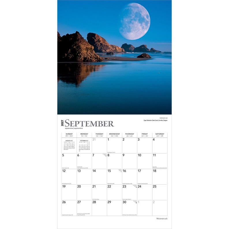 May include: A 2027 wall calendar for the month of September featuring a photograph of a large moon over a dark blue ocean and rocky coastline. The calendar grid displays the days of the month with black text on a white background, including small monthly calendars for August and October.