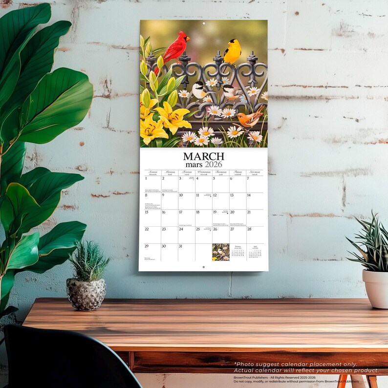 Puede incluir: Un calendario de pared para marzo de 2026 con una imagen vibrante de p&aacute;jaros posados en una valla decorativa entre flores. El calendario muestra los d&iacute;as del mes e incluye el texto "MARZO mars 2026".