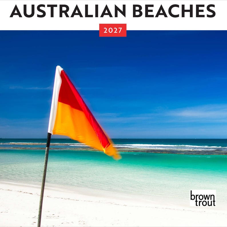 May include: A calendar titled AUSTRALIAN BEACHES 2027 featuring a red and yellow surf lifesaving flag on a pole against a bright blue sky, turquoise ocean water, and white sand. The bottom right corner displays the brand name brown trout.