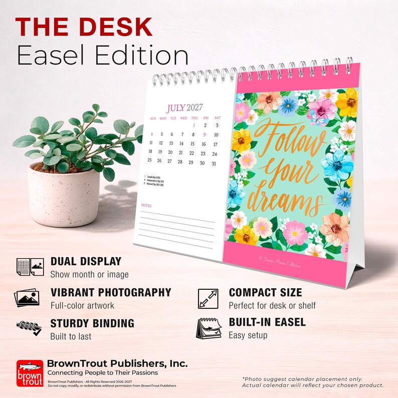 May include: A desk easel calendar featuring a spiral binding, a July 2027 monthly grid, and a floral illustration with the text Follow your dreams in gold script. The calendar has a pink border and is displayed next to a small green plant in a pot.
