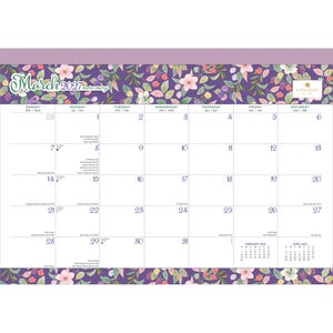 May include: A March 2027 wall calendar featuring a purple floral border with pink and white flowers and green leaves. The calendar grid displays days of the week in English, French, and Spanish, with small February and April 2027 calendars.