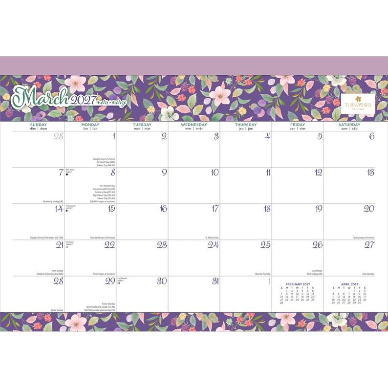 May include: A March 2027 wall calendar featuring a purple floral border with pink and white flowers and green leaves. The calendar grid displays days of the week in English, French, and Spanish, with small February and April 2027 calendars.