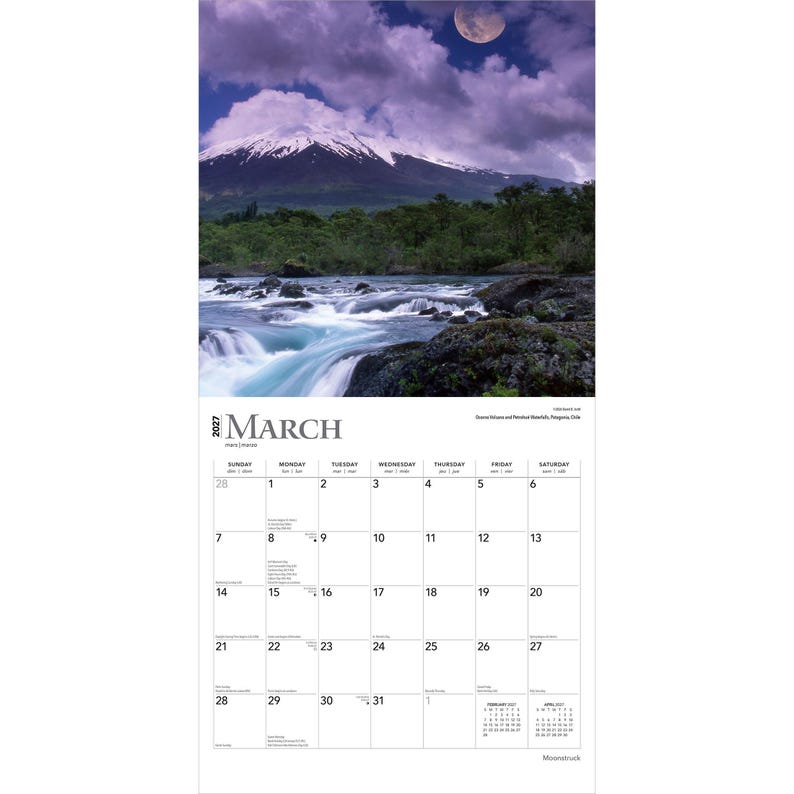 May include: A 2027 wall calendar for the month of March featuring a landscape photograph of a snow-capped mountain, a rushing river, and a moon in a cloudy purple sky. The calendar grid displays dates from the 1st to the 31st with text labels.