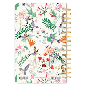 May include: A white spiral bound notebook with a colorful hummingbird and floral pattern. The cover features the text "brown trout" and "HUMMINGBIRDS".