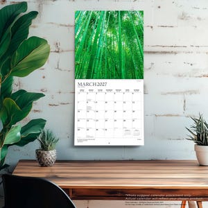 May include: A wall calendar for March 2027 featuring a vertical photograph of a dense green bamboo forest. The calendar grid displays the days of the month with clear black text on a white background, including small calendars for February and April.