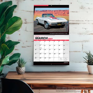 Peut inclure: Un calendrier mural pour mars 2027 pr&eacute;sentant une Chevrolet Corvette Sting Ray blanche de 1963 avec une bande rouge sur le capot, gar&eacute;e dans un paysage d&eacute;sertique. La grille du calendrier affiche le mois, l'ann&eacute;e et les dates en noir sur fond blanc.