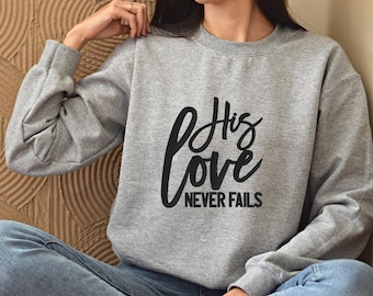 May include: Gray sweatshirt with black text that reads "His Love Never Fails".
