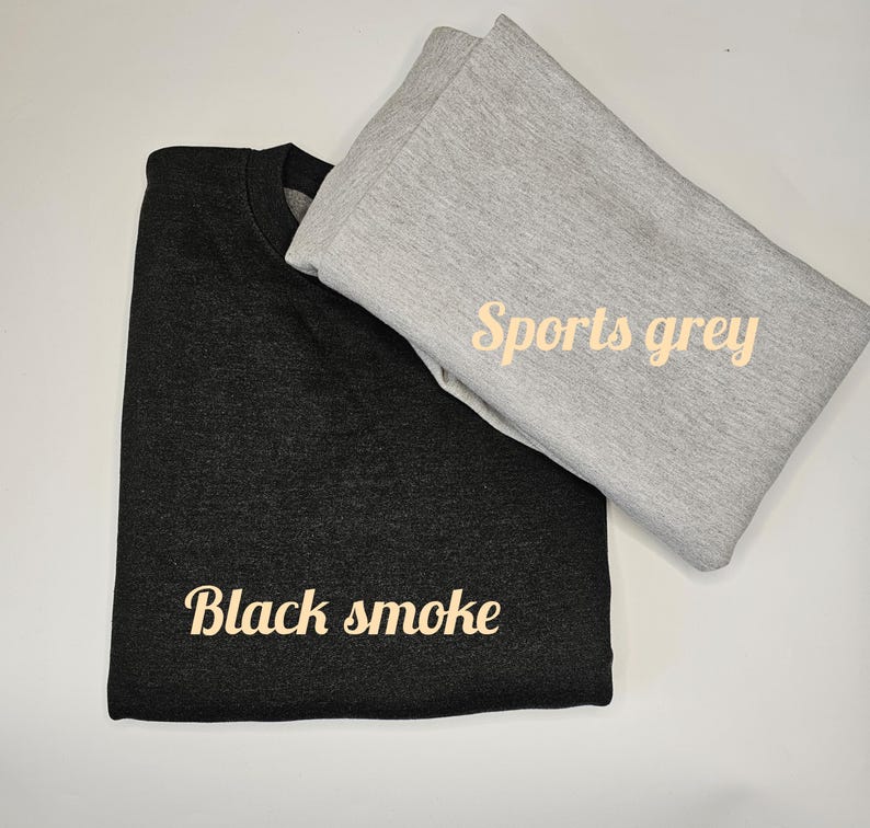 May include: Two folded sweatshirts, one black with the text "Black smoke" and one gray with the text "Sports grey".