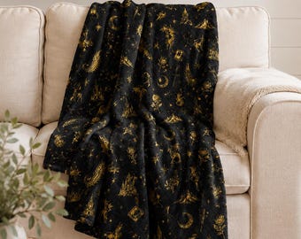 Manta de peluche con motivos literarios / Iconos celestiales en negro y dorado: lunas, coronas y dragones.