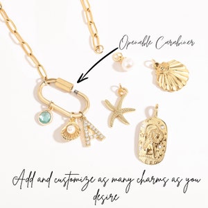 Gold paperclip chain necklace with openable clasp for customization. Includes charms like a cubic zirconia ‘A,’ pearl shell, starfish, Leo zodiac, and birthstone. Easily add or personalize charms for a unique look.