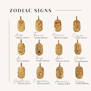 May include: A collection of twelve gold-toned oval pendants, each featuring a unique embossed zodiac sign and small embedded crystals. The text ZODIAC SIGNS appears at the top, with each pendant labeled by its name and corresponding date range.