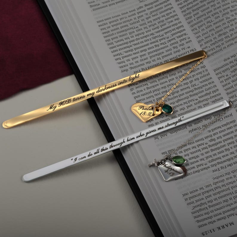 May include: Two gold and silver bookmarks with inspirational quotes. The gold bookmark reads "My GOD turns my darkness into light". The silver bookmark reads "I can do all this through him who gives me strength".
