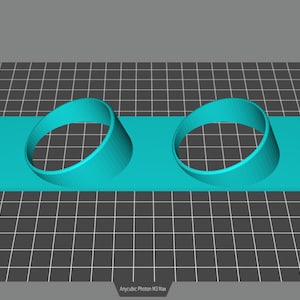 May include: A turquoise blue 3D printed plastic object with two circular cutouts. The object is designed to hold two round items, such as cups or glasses.