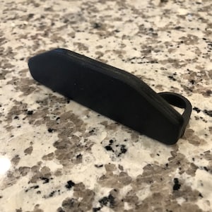 Puede incluir: Un guía de cadena de plástico negro para una bicicleta.