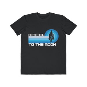 May include: Black t-shirt with a blue and white retro design featuring a rocket ship and the text "BITCOIN TO THE MOON".