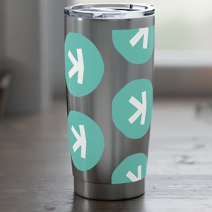 Puede incluir: Un vaso de acero inoxidable con tapa plateada. El vaso está decorado con un patrón de óvalos color turquesa, cada uno con una flecha blanca que apunta hacia arriba. El diseño se repite en toda la superficie.