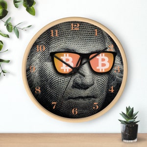May include: A round clock with a black and white image of a person wearing sunglasses with the word "B" in them. The clock face has black numbers on a white background.