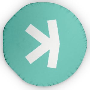 May include: A round turquoise throw pillow with a white arrow pointing to the right.