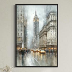 May include: A framed vertical wall art print depicting a rainy New York City street scene with the Empire State Building in the background. The artwork features muted gray and white tones, yellow taxi cabs, and pedestrians walking on wet pavement.