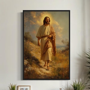 May include: A framed wall art print depicting a bearded figure in a light-coloured robe and brown shawl walking along a dusty path. The scene features a warm, golden-toned landscape with a glowing halo effect around the figure's head.
