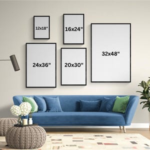 Op de afbeelding: Vijf ingelijste kunstdrukken met zwarte frames en witte interieurs, vari&euml;rend in grootte van 30x46 cm tot 81x122 cm, worden weergegeven op een beige muur. Een blauwe bank met kussens en een potplant staan voor de muur.