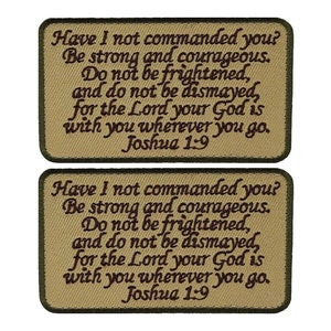 May include: Two beige fabric patches with green borders, each featuring the same embroidered text in brown: "Have I not commanded you? Be strong and courageous. Do not be frightened, and do not be dismayed, for the Lord your God is with you wherever you go. Joshua 1:9"
