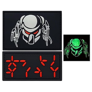 May include: Two black patches with white and red designs. The top patch features a white Predator alien head with red eyes. The bottom patch features a red digital display with the text "11111111".