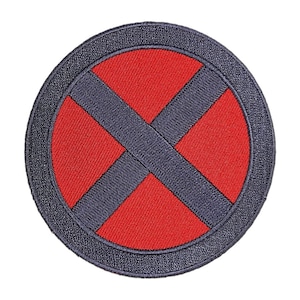 May include: A red and black embroidered patch with an X shape in the center. The patch is circular and has a black border.