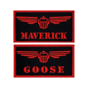 May include: Two black embroidered patches with red stitching. The top patch says "MAVERICK" and the bottom patch says "GOOSE". Both patches feature a red winged emblem with a shield in the center.