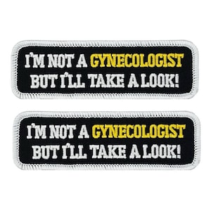 May include: Two black rectangular patches with white stitching around the edges. The patches have white text that reads "I'M NOT A GYNECOLOGIST BUT I'LL TAKE A LOOK!" with the word "GYNECOLOGIST" in yellow.