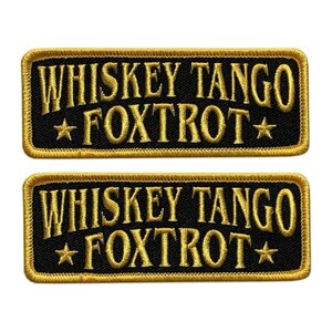 May include: Two black and gold embroidered patches with the text "Whiskey Tango Foxtrot" in gold lettering. Each patch has a gold star on either side of the text.