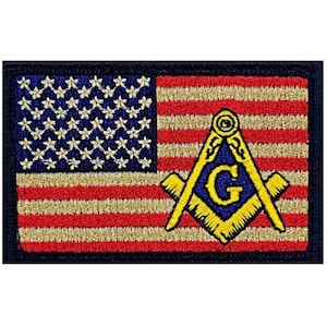 May include: An embroidered patch featuring the American flag with a yellow Masonic symbol superimposed on the stripes. The symbol includes a compass and square with a 'G' in the center.