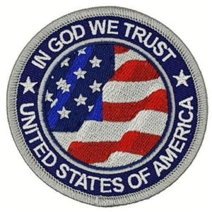 May include: Circular patch featuring the American flag design with red and white stripes and a blue field with white stars. The text "IN GOD WE TRUST" and "UNITED STATES OF AMERICA" are embroidered around the flag.