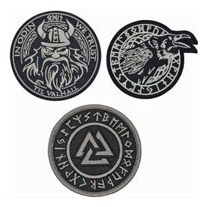 May include: Three black and white embroidered patches with Norse mythology themes. The first patch features a Viking with a beard and horns, the second patch features a raven, and the third patch features a Valknut symbol.