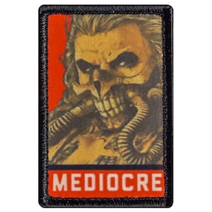 May include: A rectangular patch with a black border and a red background. The patch features a detailed illustration of a skull-like face with tubes and the word "MEDIOCRE" in white block letters.