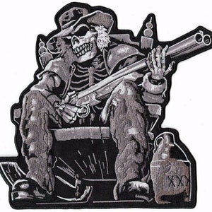 May include: A black and white embroidered patch of a skeleton wearing a hat and holding a shotgun. The skeleton is sitting on a chair with a jug of moonshine next to it. The patch has a distressed look and is perfect for adding a touch of outlaw style to your jacket or bag.