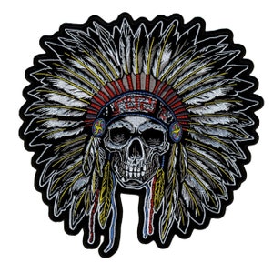 May include: Embroidered patch of a skull wearing a Native American headdress with red, white, and blue feathers. The skull is white with black eye sockets and a black mouth.