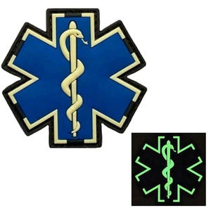 May include: A blue and white star of life patch with a white snake and rod symbol. The patch is glow-in-the-dark and has a black border.