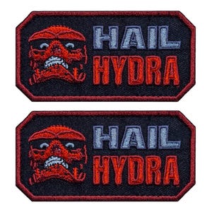 May include: Two rectangular patches with a red skull design and the words "HAIL HYDRA" embroidered in blue and red. The patches have a black background and a red border.