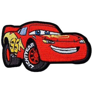 May include: Embroidered patch featuring Lightning McQueen from the Cars movie. The red car has blue eyes, a smiling mouth, and the number 95 with a lightning bolt on the side. The wheels are black, and the text "LIGHTYEAR" is on the tire.