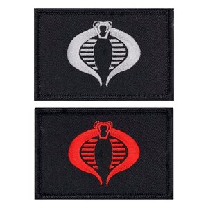 May include: Two black fabric patches with the Cobra symbol embroidered in white and red. The Cobra symbol is a stylized cobra head with a crown on top.