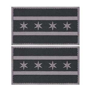 May include: Two black and white embroidered patches featuring the Chicago flag. The flag has four white stars on a white stripe, with two white stripes above and below the star stripe.