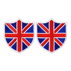 May include: Two embroidered patches in a shield shape, featuring the Union Jack flag design. The patches have a blue background with red and white accents, and a white border. The patches are suitable for clothing or accessories.