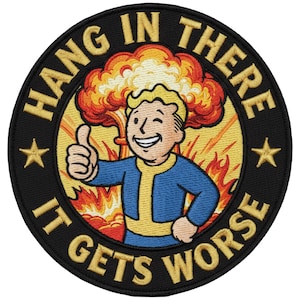 May include: Embroidered patch with the text "HANG IN THERE IT GETS WORSE" in gold lettering on a black background. The patch features a cartoon character giving a thumbs up in front of an atomic explosion.
