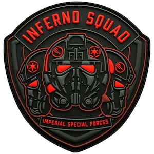 May include: A black and red Inferno Squad patch featuring three stylized helmets. The text "INFERNO SQUAD" arches across the top, with "IMPERIAL SPECIAL FORCES" at the bottom. The patch has a textured, raised design.