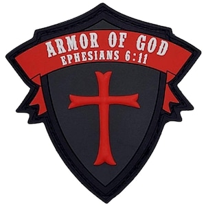 May include: A black and red patch with a shield shape and a red cross in the center. The text "Armor of God Ephesians 6:11" is on a red banner.