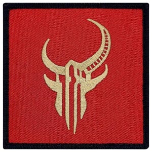 May include: Embroidered patch featuring a cream-colored, stylized emblem on a red background. The emblem has a central vertical element with curved horns and decorative details. The patch is square with a black border.