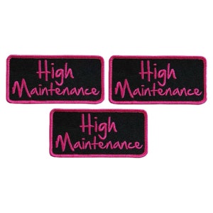 May include: Three black iron-on patches with pink embroidered text that reads "High Maintenance".