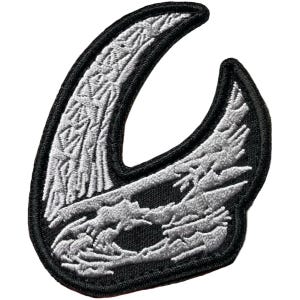 May include: Embroidered patch featuring a stylized, abstract design in shades of gray and white against a black background. The patch has a curved, crescent-like shape with intricate detailing, and a black border.