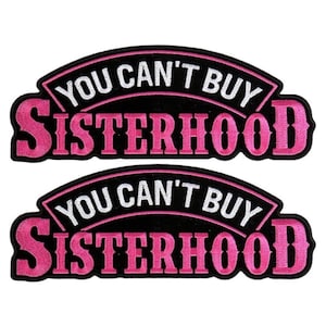 May include: Two black and pink embroidered patches with the text "You can't buy sisterhood".
